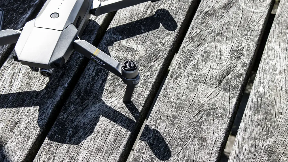 Ingeklapte DJI-drone op een houten vlonder in de zon
