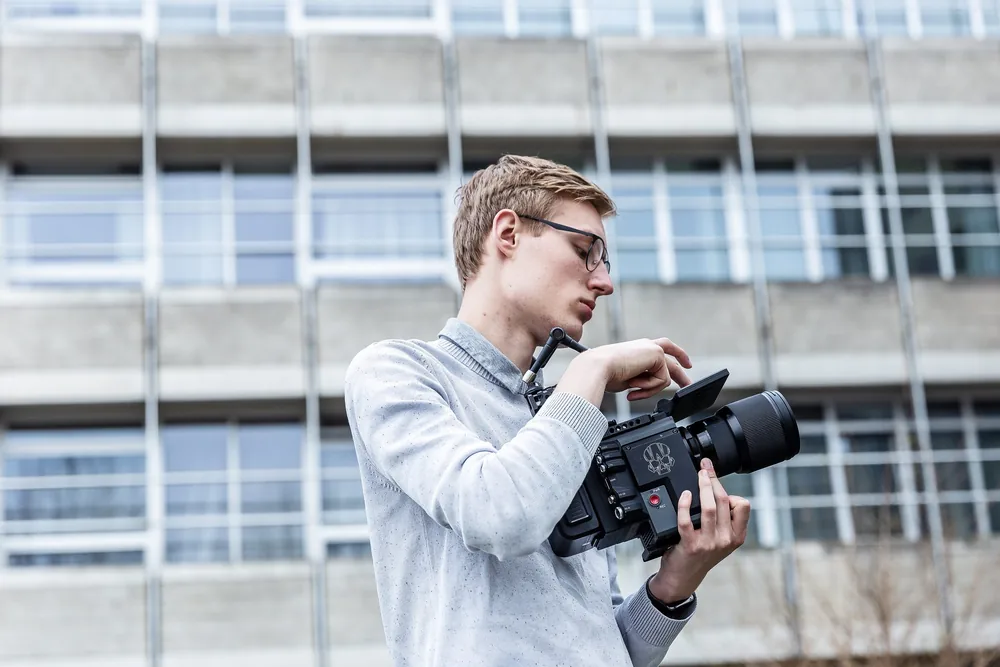 Seth Esenkbrink stelt zijn camera in voor een opname bij een gebouw