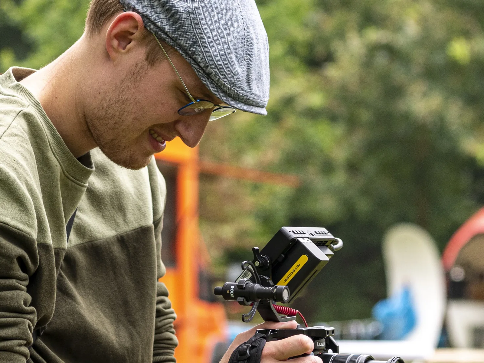 Seth Esenkbrink stelt lachend zijn Panasonic-camera in tijdens een opname op locatie